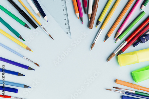 Frame of colour pencils and paintbrushes
