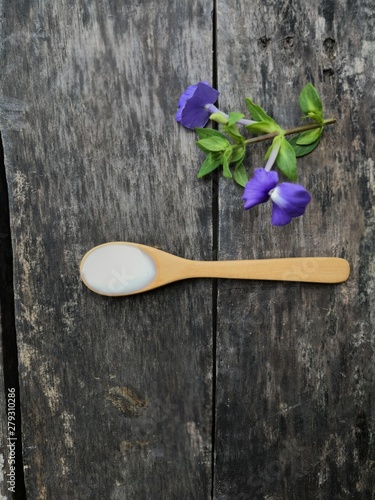 Yogurt on a wooden spoon, placed on a black wood floor photo