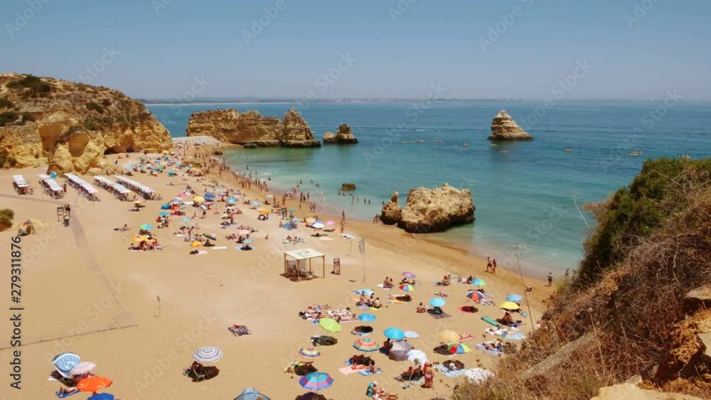 Wide elevated view of the Dona Ana beach in Lagos, The Algarve, Portugal, with beautiful rock formations and turquoise waters Wide elevated view of the Dona Ana beach in Lagos, The Algarve, Portugal, with beautiful rock formations and turquoise waters