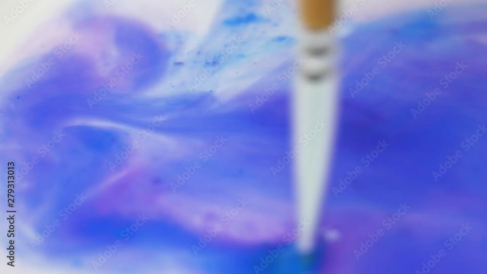 Artist Clean a Colored Paint Brush and Spread Violet Color in Clear Water Artist Clean a Colored Paint Brush and Spread Violet Color in Clear Water