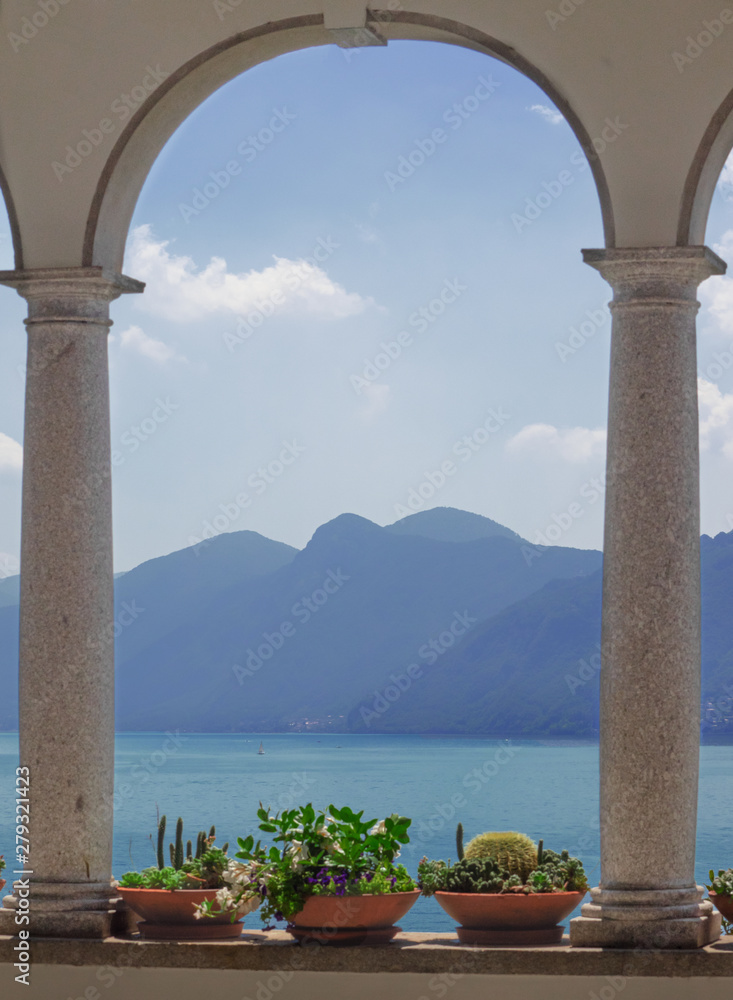window with stone columns overlooking the lake and the mountains.Como Lake, Italy