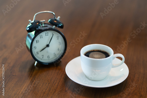 Hot coffee cup and vintage clock time at 8 o'clock in the morning