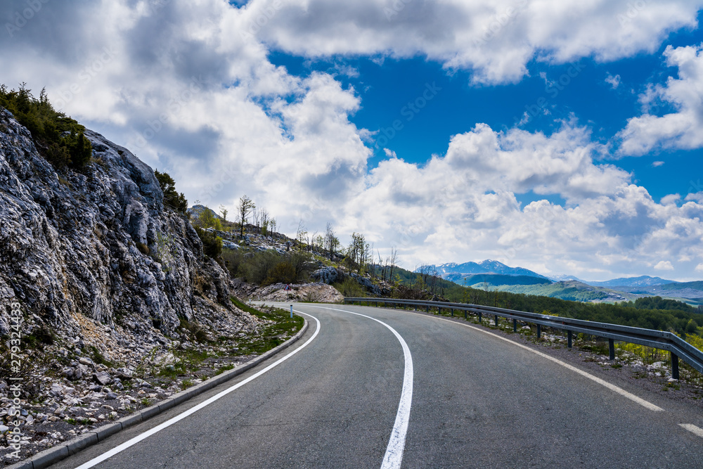 Montenegro, Curved road through beautiful green rocky nature landscape of country scenery and forest near savnik in springtime with bue sky Montenegro, Curved road through beautiful green rocky nature landscape of country scenery and forest near savnik in springtime with bue sky
