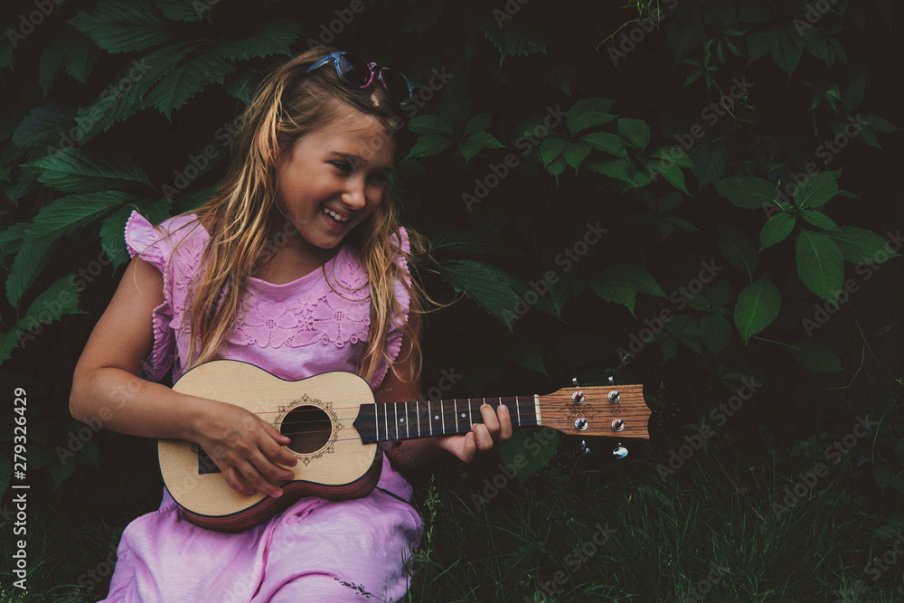 Rusland Peru siv Beautiful young girl with blond hair wearing pink dress playing ukulele and  smiling on dark nature background. Grape leaves. Cutie lady learns play  guitar concept Stock Photo | Adobe Stock