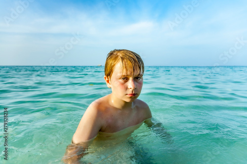 angry young boy is walking thru the clear warm saltwater