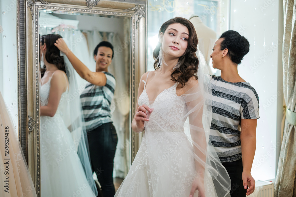 Beautifu bride choosing wedding dress in a wedding salon Beautifu bride choosing wedding dress in a wedding salon