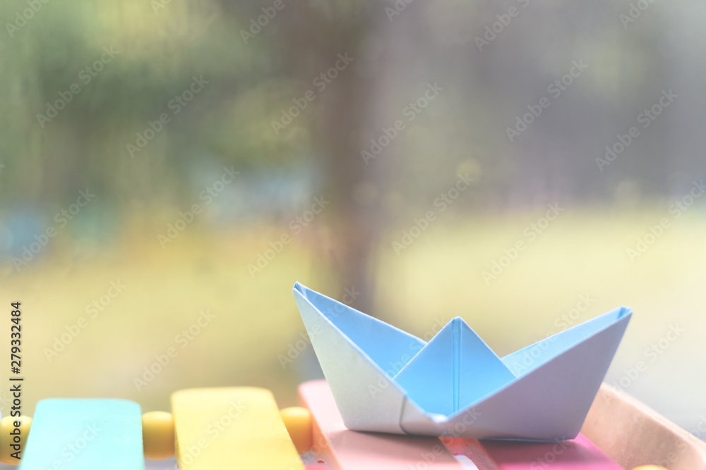 Origami boat by a window on a rainy day inside the house