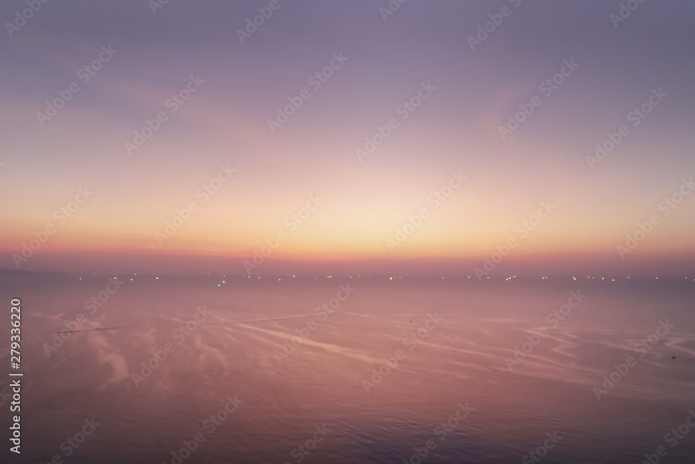 Dramatic atmosphere panorama aerial view of beautiful twilight sky with cloud and sea texture wave show small light bokeh of fishing boats background for silhouette object.