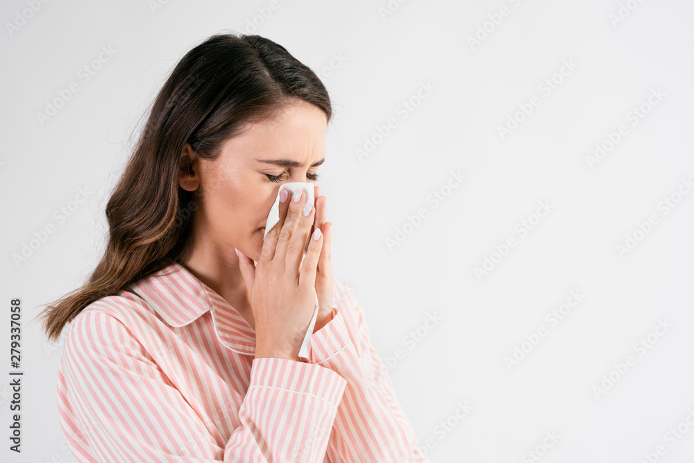 Young woman blowing her nose in studio shot Young woman blowing her nose in studio shot