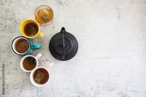 top view of colorful group of cups with different teas on white background