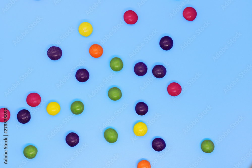 Colorful candy closeup on a blue background, sweet background.