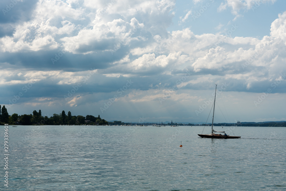 sailboat returns to the harbor at Altnau on Lake Constance with a storm slowly moving in