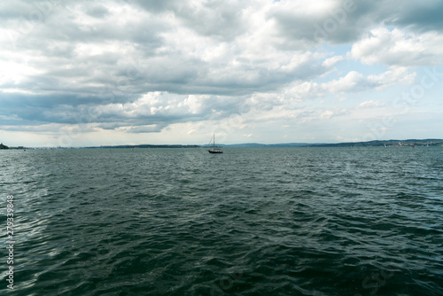 sailboat returns to the harbor at Altnau on Lake Constance with a storm slowly moving in