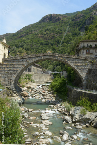 The river and the ancient Roman bridge in the town of Pont St Martin in the Aosta Valley - Italy