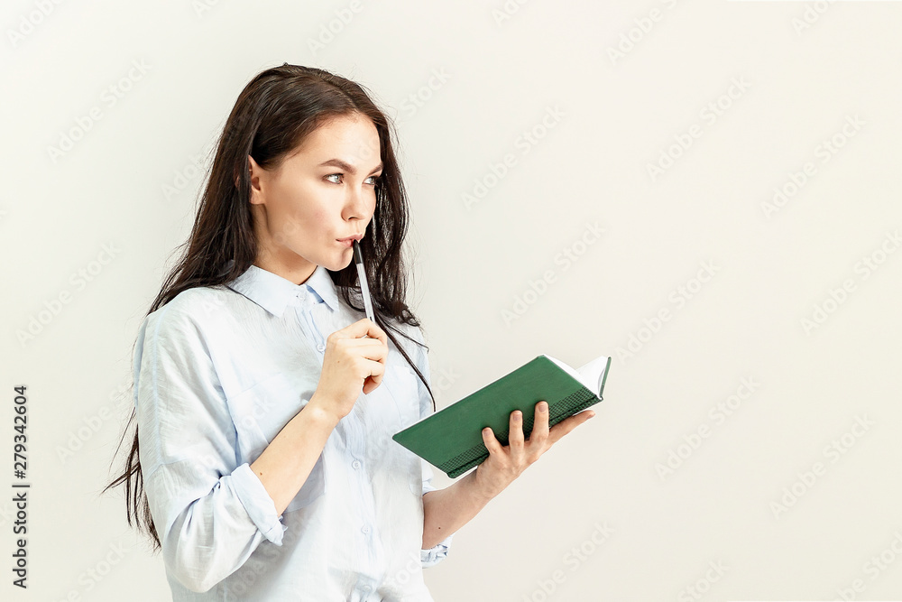 Young beautiful girl with a diary, a notebook and a pen in her hands Young beautiful girl with a diary, a notebook and a pen in her hands
