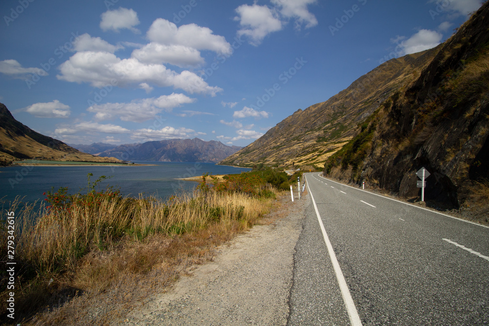 a road trough the nature of New-Zealand with mountains and a lake