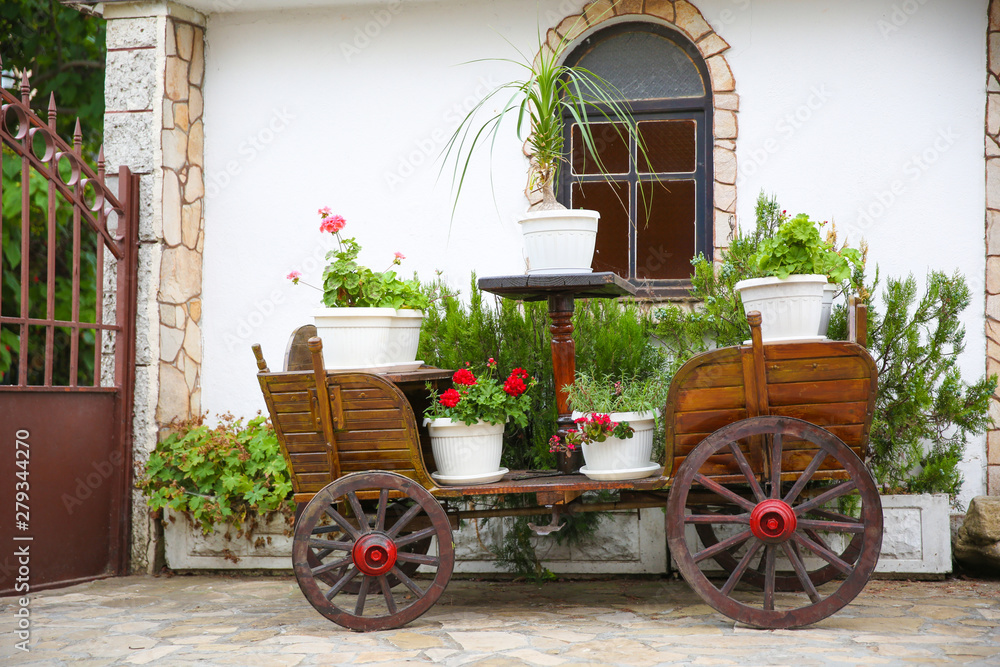 vintage carriage in the form of a decoration. flowers in pots on a horse cart