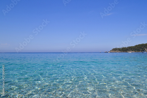 Sea view. Transparent water and calm turquoise sea with sun highlights