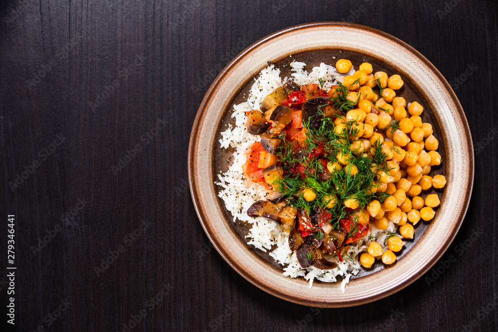 Rice with chickpea and vegetables on wooden table Rice with chickpea and vegetables on wooden table