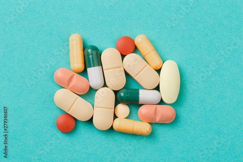 colour tablets and pills on blue background .