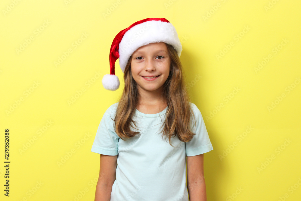 cheerful girl on a colored background in the Christmas hat cheerful girl on a colored background in the Christmas hat