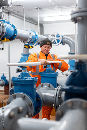 Diligent worker in public water utility turning a valve to open a pipe