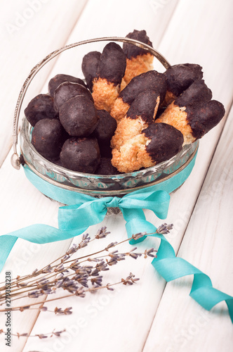 Useful candy homemade chocolate in vintage dish on white wooden background with branch of lavender