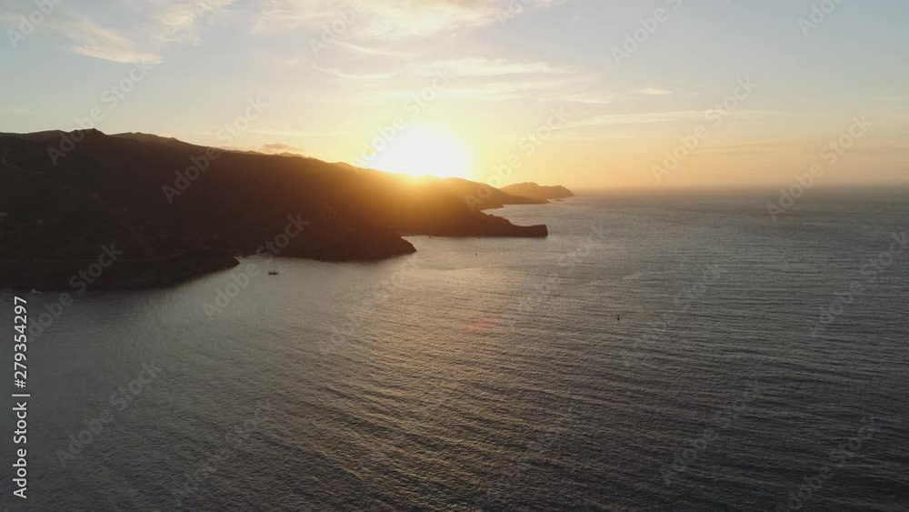 Aerial shot flying high over the ocean towards island at sunset. Beautiful light with dark coastline, southern California. Aerial shot flying high over the ocean towards island at sunset. Beautiful light with dark coastline, southern California.