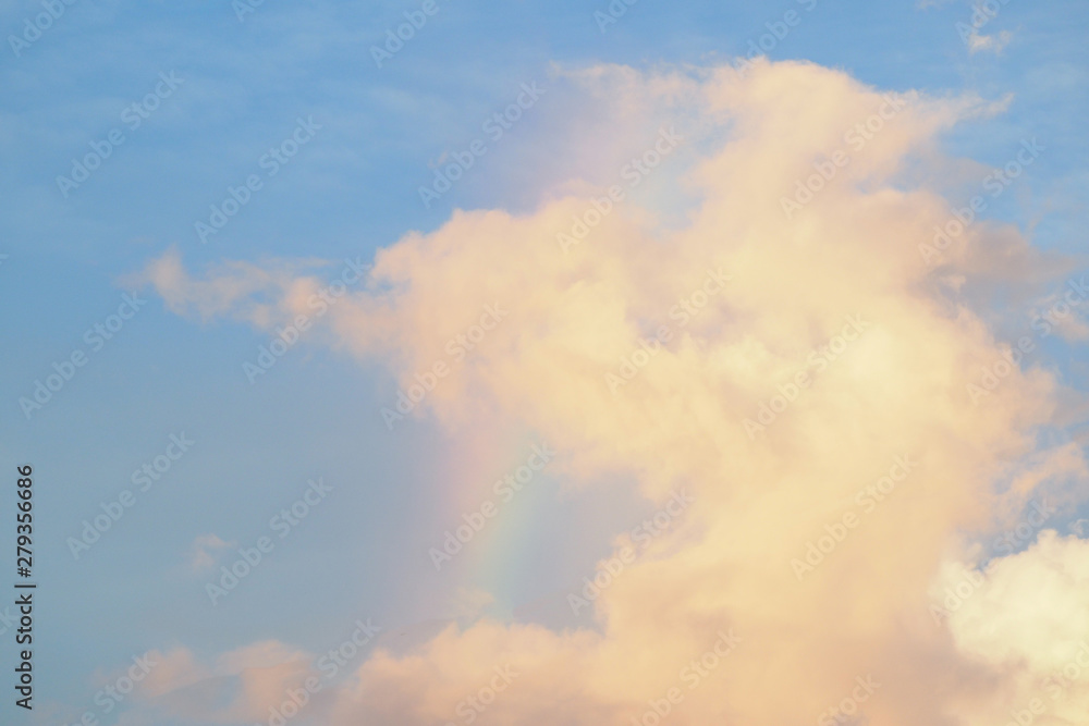 Obraz premium Pink clouds at sunset with a rainbow.