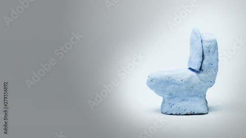 The toilet that is made of clay on the background is empty.