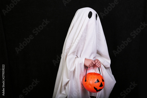 White Ghost with a pumpkin on black background. Halloween holiday party. © maximilian_100