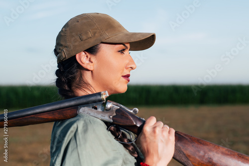 Hunter with a rifle on her shoulder.