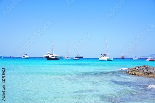 Yachten und Katamaran im karibischen Meer am Horizont im klaren türkisen Wasser