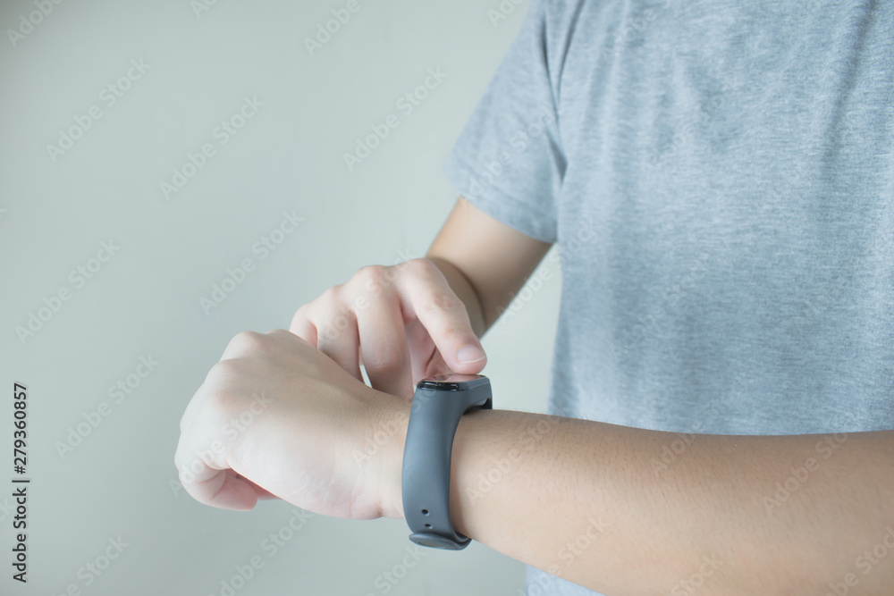 The hands of people wearing gray T-shirts are using a smart watch to check the heart rate that is worn on the wrist. The hands of people wearing gray T-shirts are using a smart watch to check the heart rate that is worn on the wrist.