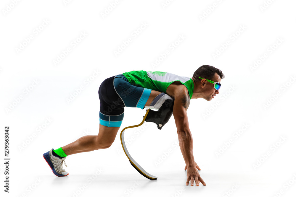 Athlete with disabilities or amputee isolated on white studio background. Professional male runner with leg prosthesis training and practicing in studio. Disabled sport and healthy lifestyle concept. - obrazy, fototapety, plakaty 