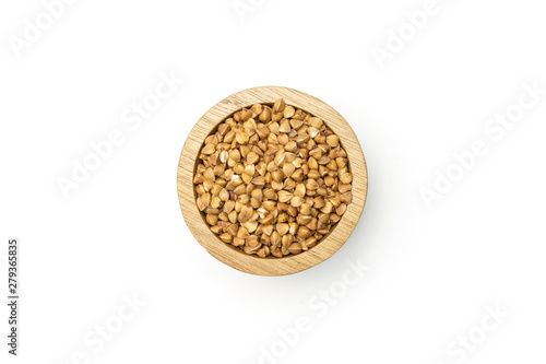 Closeup of lot of whole raw brown buckwheat grain in a wooden bowl flatlay isolated on white background photo
