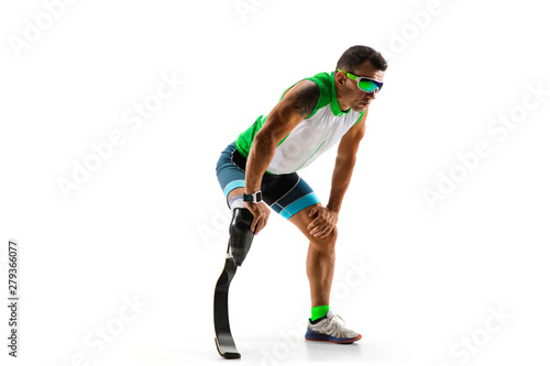 Athlete with disabilities or amputee isolated on white studio background. Professional male runner with leg prosthesis training and practicing in studio. Disabled sport and healthy lifestyle concept.