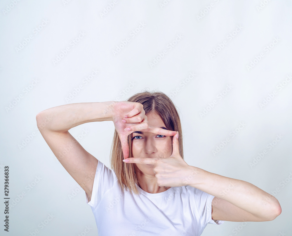 Girl made a rectangular frame of fingers opposite her eyes. Girl made a rectangular frame of fingers opposite her eyes.