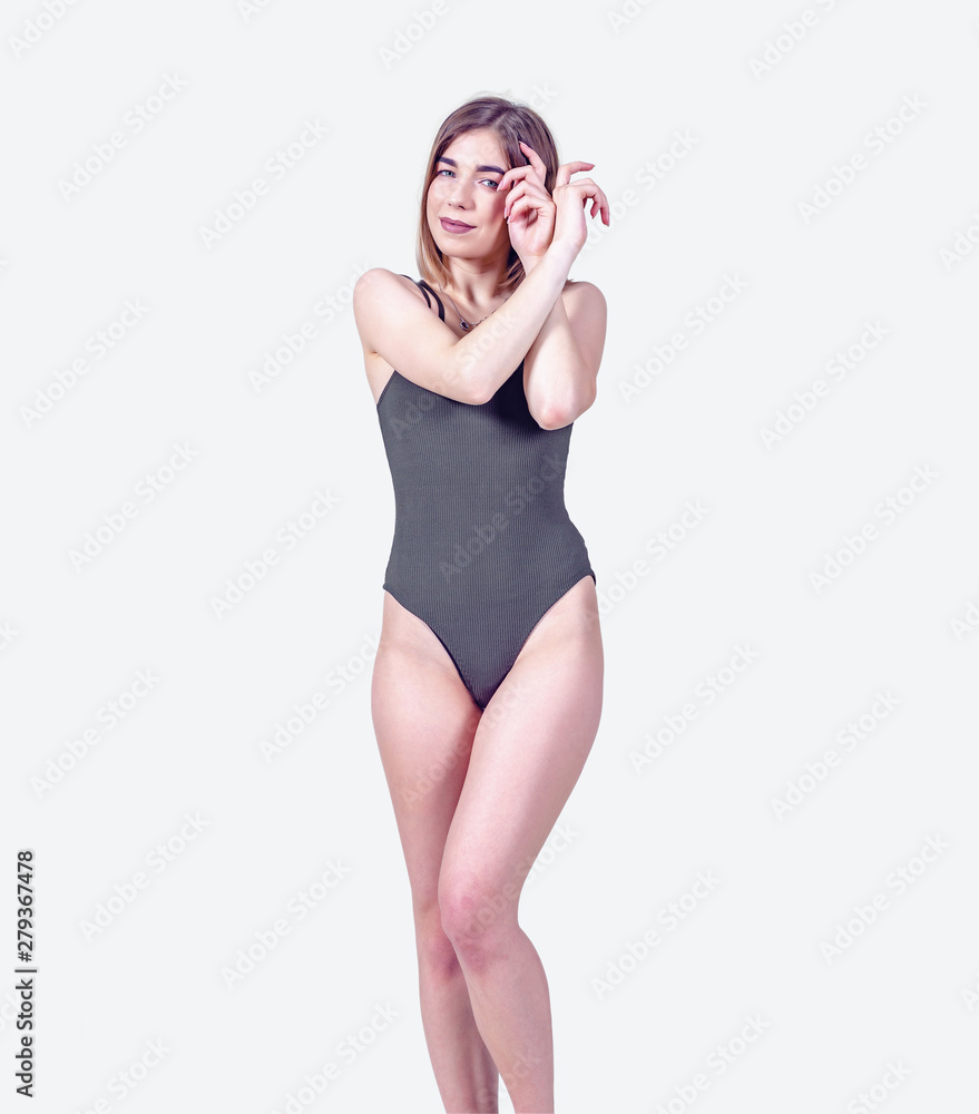 Slender girl in the bodysuit stands in full growth on a white background. Beautiful figure, sexy, calm Slender girl in the bodysuit stands in full growth on a white background. Beautiful figure, sexy, calm