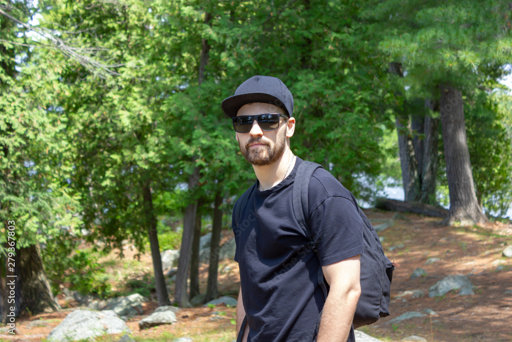 man in black sunglasses and a black t-shirt in the woods man in black sunglasses and a black t-shirt in the woods