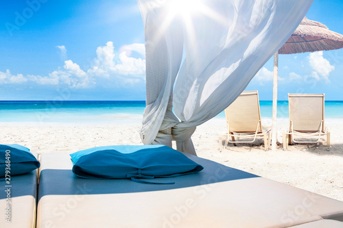 Relaxing time at the seaside. Sunbathing and resting woman on sun bed. Resting person on the beautiful sunny beach.
