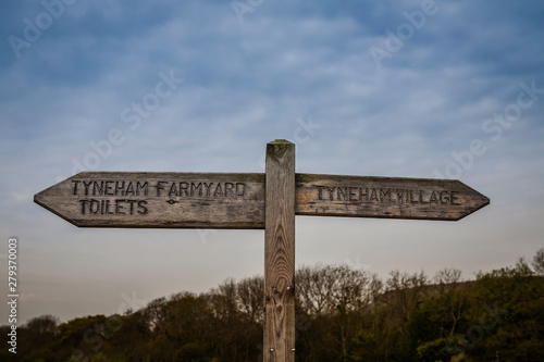 a wooden sign for tyneham village and farmyard - requisitioned by the army in wwii and now a museum