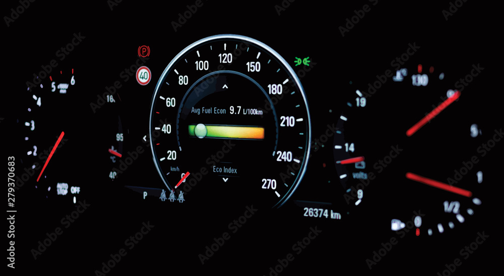 Illustration of side view of modern car dashboard with speedometer, tachometer, odometer, car's temperature gauge. Selective focus of average fuel economy consumption display on car instrument panel. 