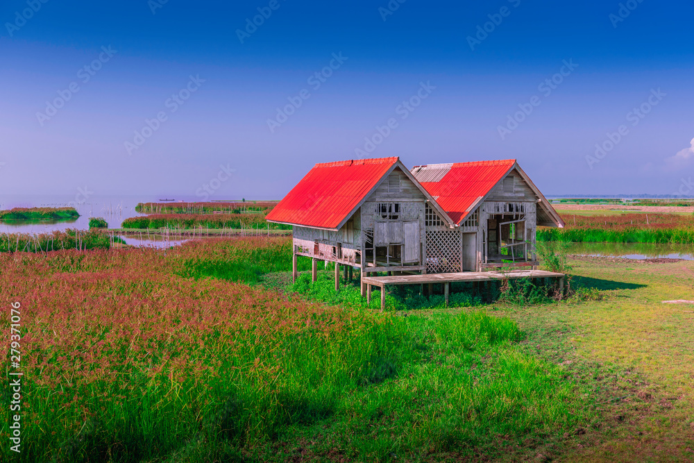 Dilapidated of landmark twin house at Talaynoi with blue sky, Chaloem Phrakiat Bridge, Phattalung in Thailand. Dilapidated of landmark twin house at Talaynoi with blue sky, Chaloem Phrakiat Bridge, Phattalung in Thailand.