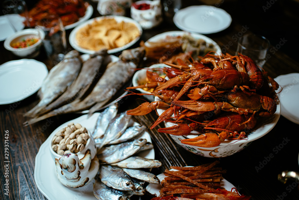 boiled crayfish, salted fish, snacks on a wooden table boiled crayfish, salted fish, snacks on a wooden table