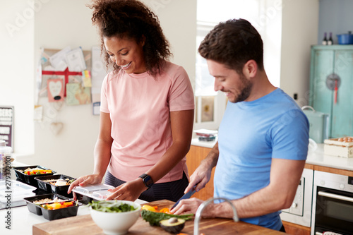 Φωτογραφία Couple Preparing Batch Of Healthy Meals At Home In Kitchen Together