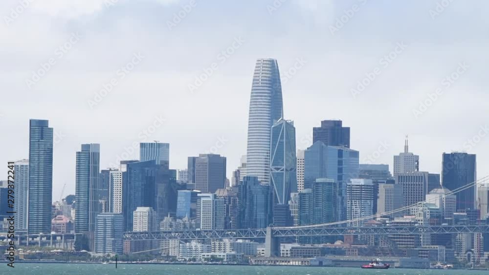 HD video of San Francisco and the bay bridge in the summer, heavy marine layer wind blowing clouds through the city reflecting in windows of the buildings as ships sit in the bay. HD video of San Francisco and the bay bridge in the summer, heavy marine layer wind blowing clouds through the city reflecting in windows of the buildings as ships sit in the bay.