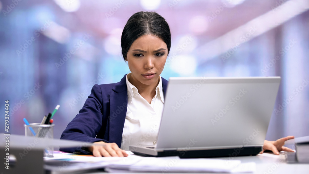 Sad female employee looking at documents on table, overwork exhaustion, stress Sad female employee looking at documents on table, overwork exhaustion, stress
