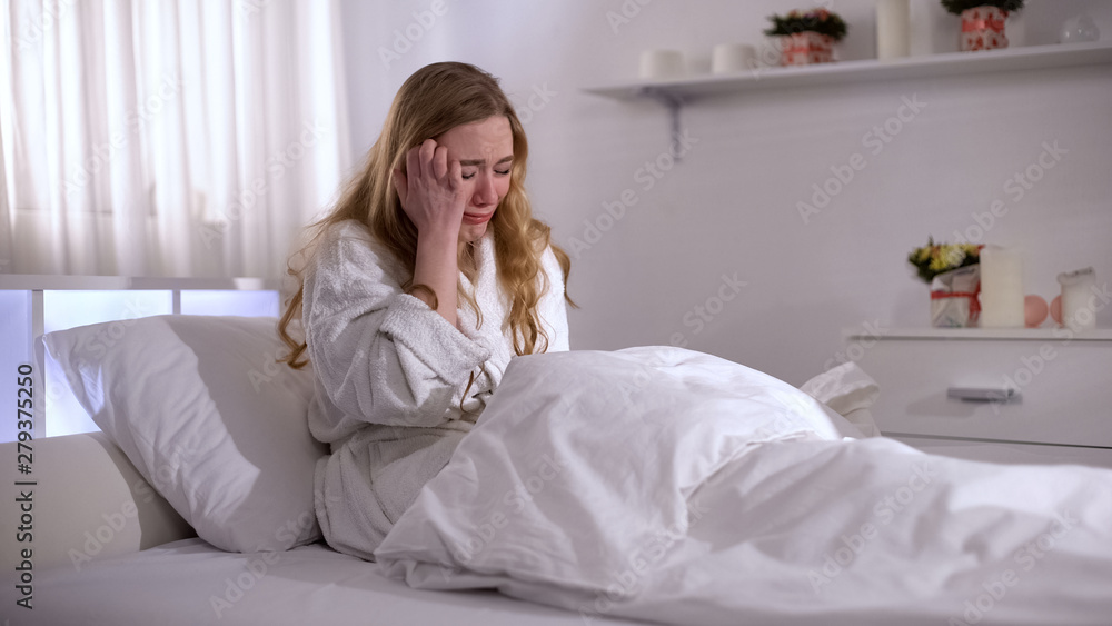 Depressed young woman crying in bed, pain of relative loss, grief and sorrow Depressed young woman crying in bed, pain of relative loss, grief and sorrow