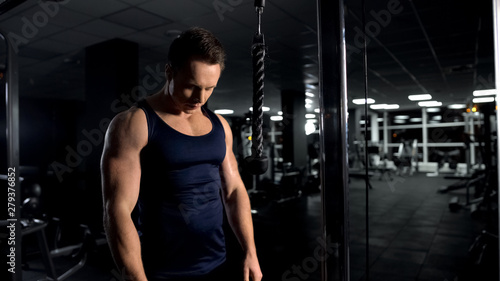 Strong man preparing for arm muscles workout, triceps cable pushdown exercise